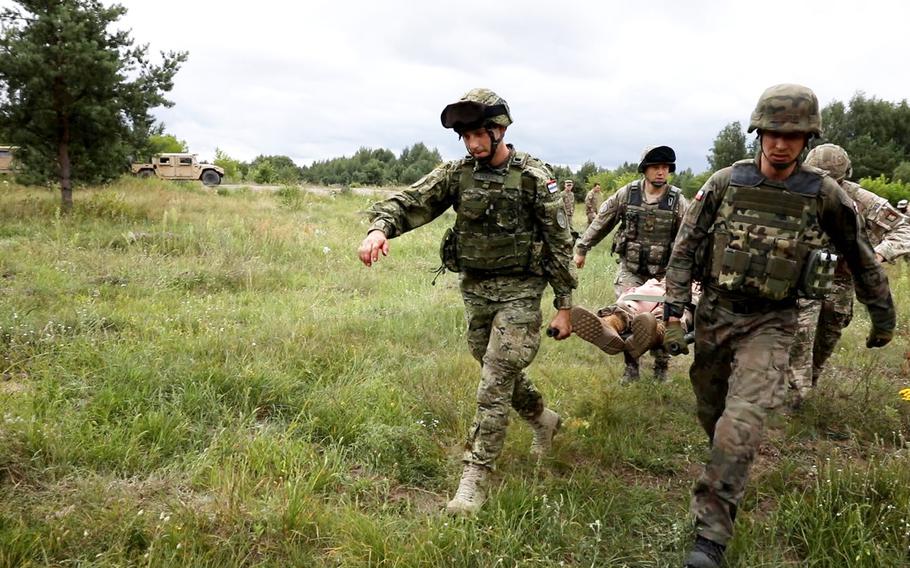 One of the teams competing in the Interoperability Games in Bemowo Piskie, Poland, carries a simulated casualty, Saturday, August 3, 2019.