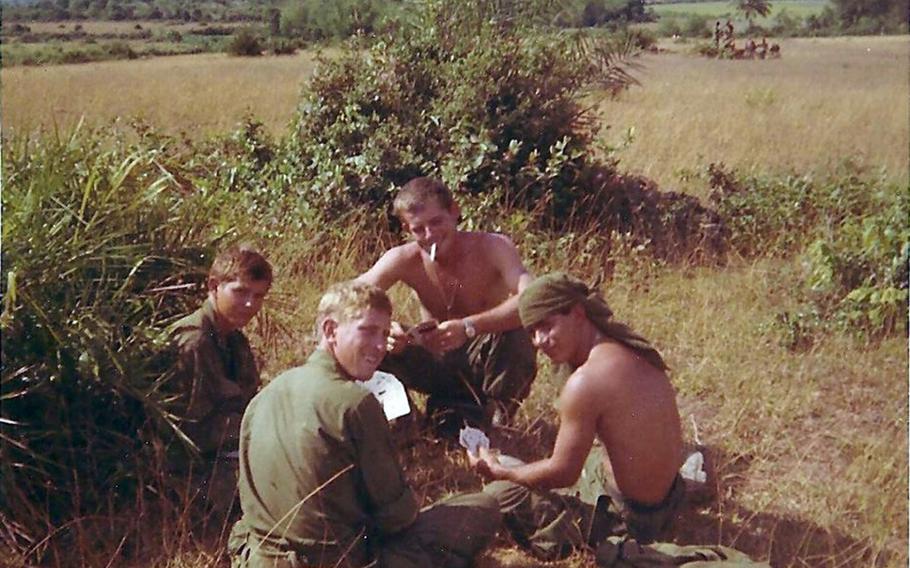 Spc. Clifford Van Artsdalen, left, plays cards with his fellow platoon members on May 5, 1968, as they await a helicopter shuttle to Hill 352 on Nui Hoac Ridge, South Vietnam.