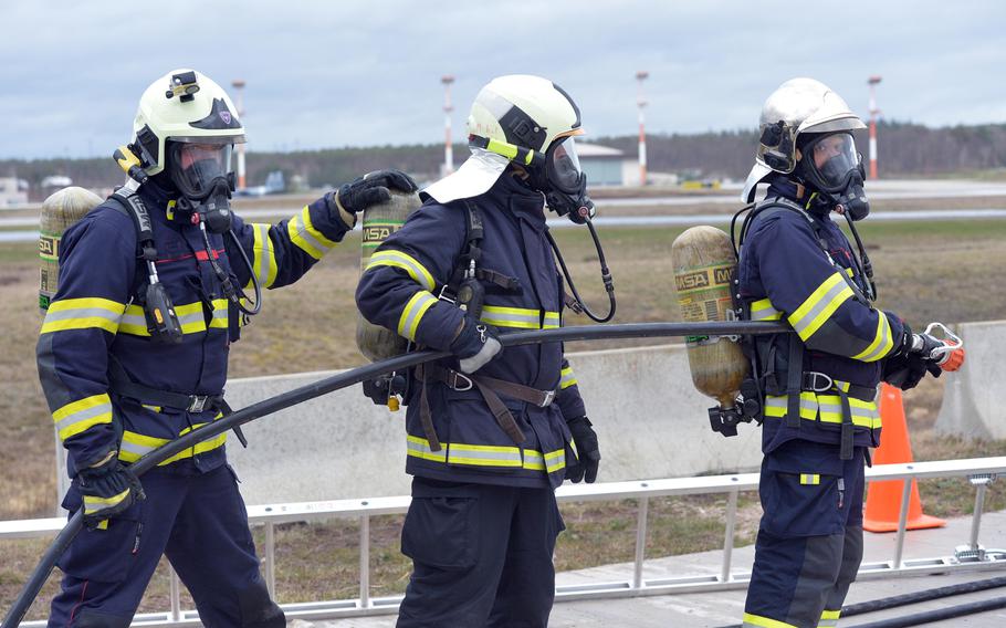 Czech firefighters get ready to put out a fire on a mockup of a fighter jet at Ramstein Air Base, Germany, March 11, 2020. Firefighters from four NATO nations practiced putting out fires at the USAFE Fire Academy on Ramstein Air Base.