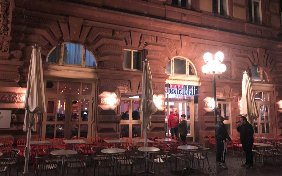 Only a handful of customers are seen outside a popular cafe in the pedestrian zone in Kaiserslautern, Germany at night. 