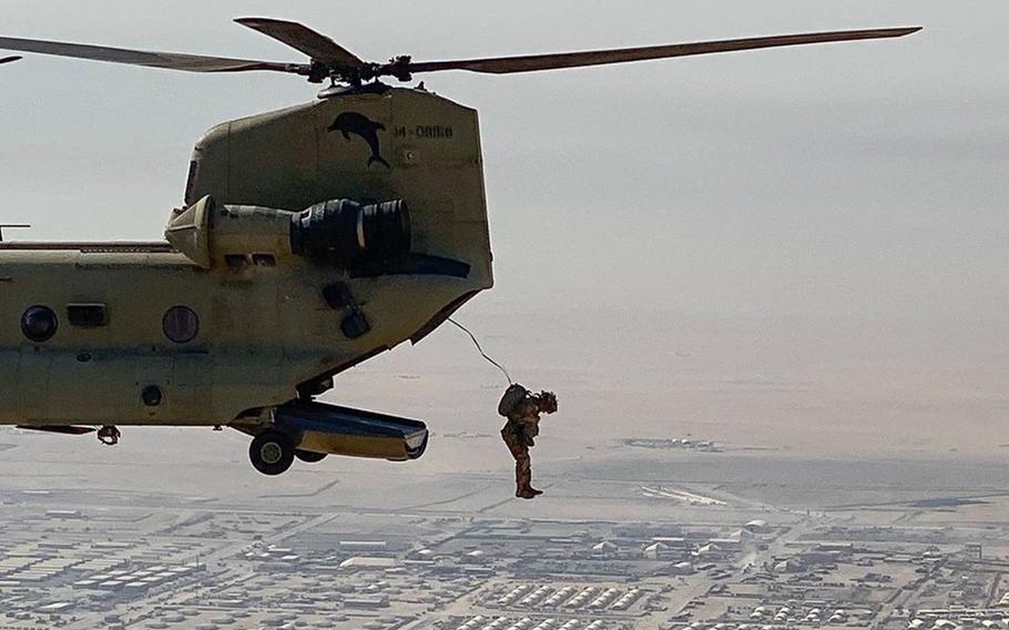 A soldier from the 1st Brigade Combat Team, 82nd Airborne Division jumps from a CH-47 Chinook over Kuwait, March 11, 2020. Some 2,500 soldiers who rapidly deployed to the Middle East days after Christmas are now separated from their families indefinitely as the military works to fight the spread of the coronavirus.