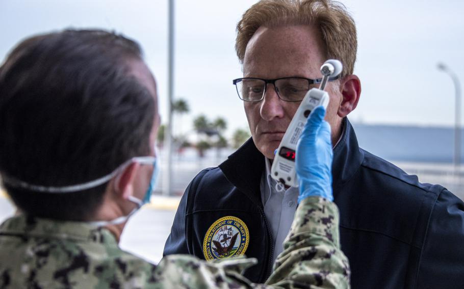 Acting Secretary of the Navy Thomas B. Modly has his temperature read as part of a coronavirus screening in Los Angeles, March 31, 2020. Modly criticized the former captain of the aircraft carrier USS Theodore Roosevelt, Capt. Brett Crozier, over the ship's loudspeakers in a speech to the crew Monday. Modly fired Crozier last week after a memo asking for the evacuation of sailors from the ship was leaked to the San Francisco Chronicle.