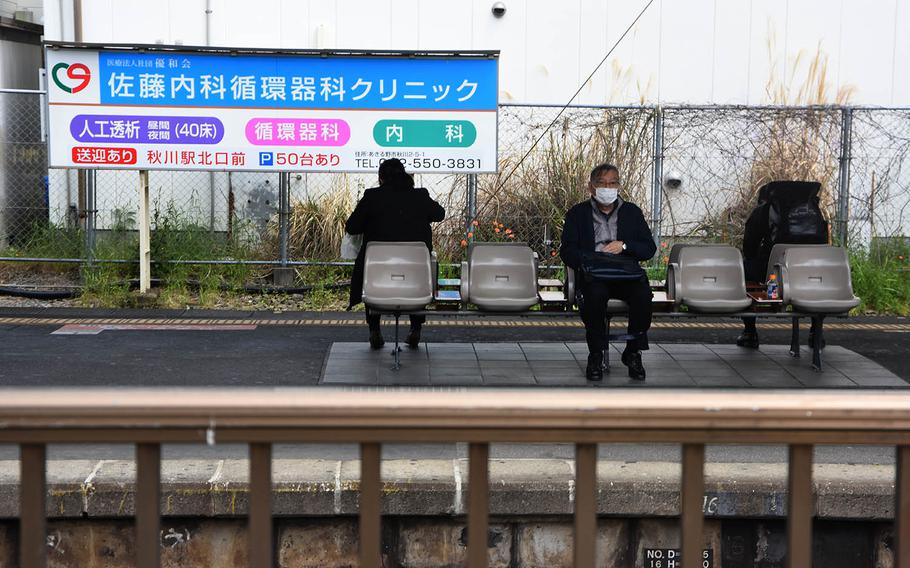 Travelers wearing masks to ward off coronavirus in Fussa, a city within Tokyo, wait for trains at the city's main station on Friday, April 17, 2020.