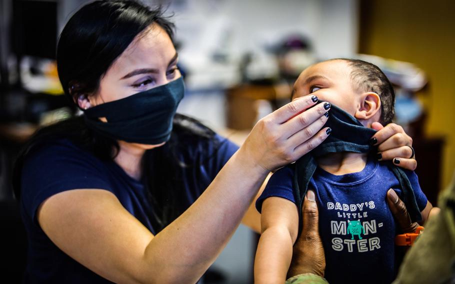 Spc. Rosa Munroe, assigned to the Joint Multinational Readiness Center at Hohenfels, Germany, places a mask made from a T-shirt on her son, April 7, 2020. Beginning next week, it will become mandatory to wear facial masks in stores and when using public transportation in Bavaria.