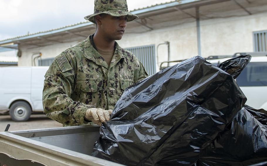 Petty Officer 3rd Class Brian Real dumps trash, as part of one of many additional cleaning teams tasked as a countermeasure to contain the spread of the coronavirus at Camp Lemonnier, Djibouti, April 6, 2020.