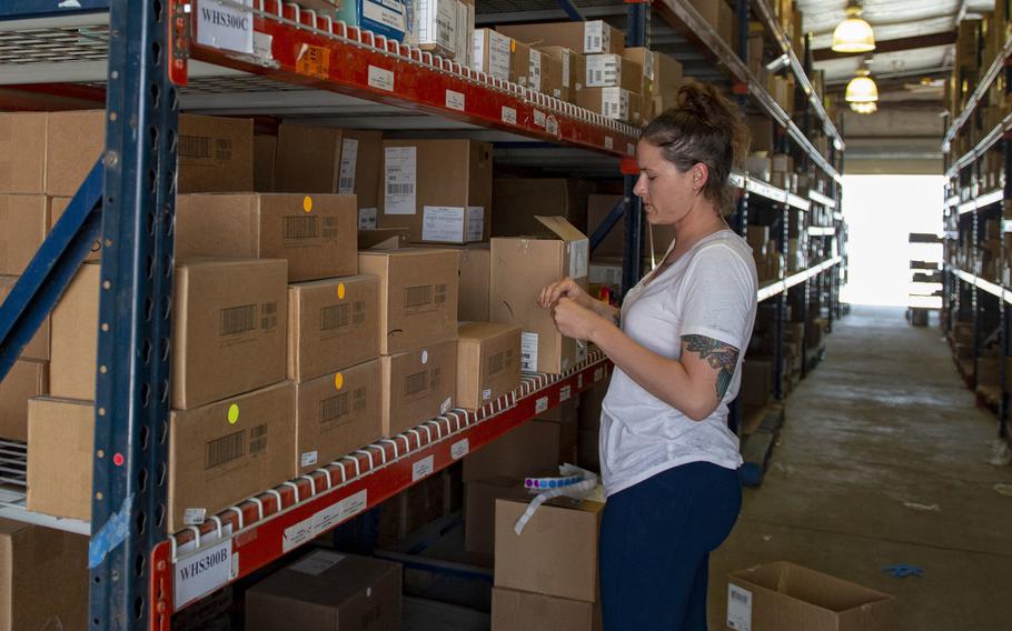 Petty Officer 2nd Class Trisha Davidson volunteers to assist the Navy Exchange in restocking items in the warehouse at Camp Lemonnier, Djibouti, April 5, 2020.