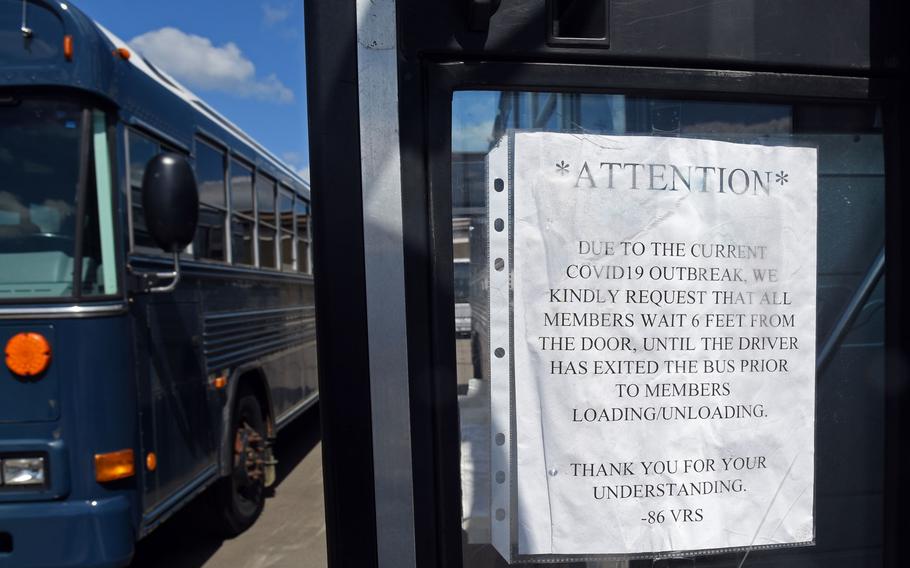 A sign posted on the door of a bus at Ramstein Air Base, Germany, asks passengers to stand back while the driver exits before they embark. The measure is intended to reduce contact between passengers and the driver during the coronavirus pandemic.