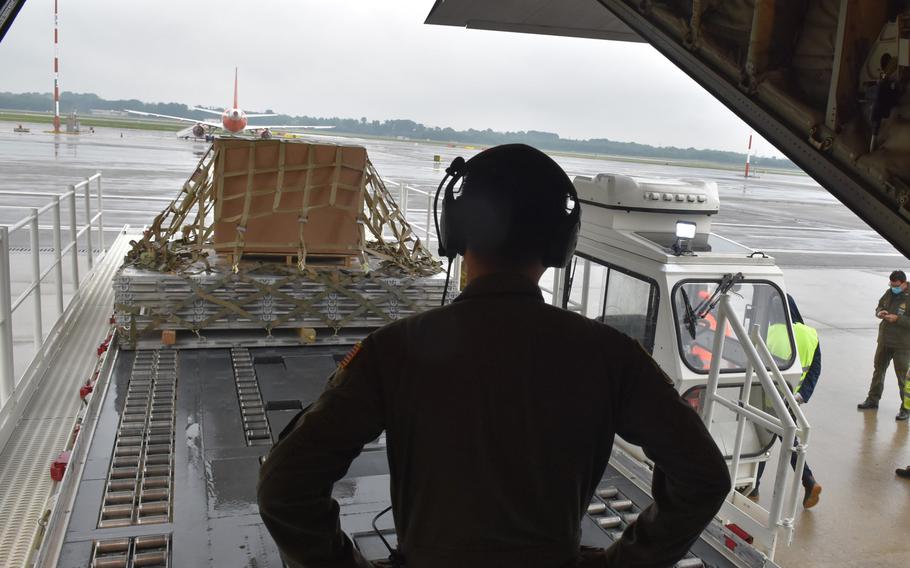 Senior Airman David Tan, 86th Operations Support Squadron aircraft loadmaster, watches as an Italian cargo loader places a pallet for loading into a C-130J Super Hercules in Milan, Italy, on Wednesday, May 13, 2020.
