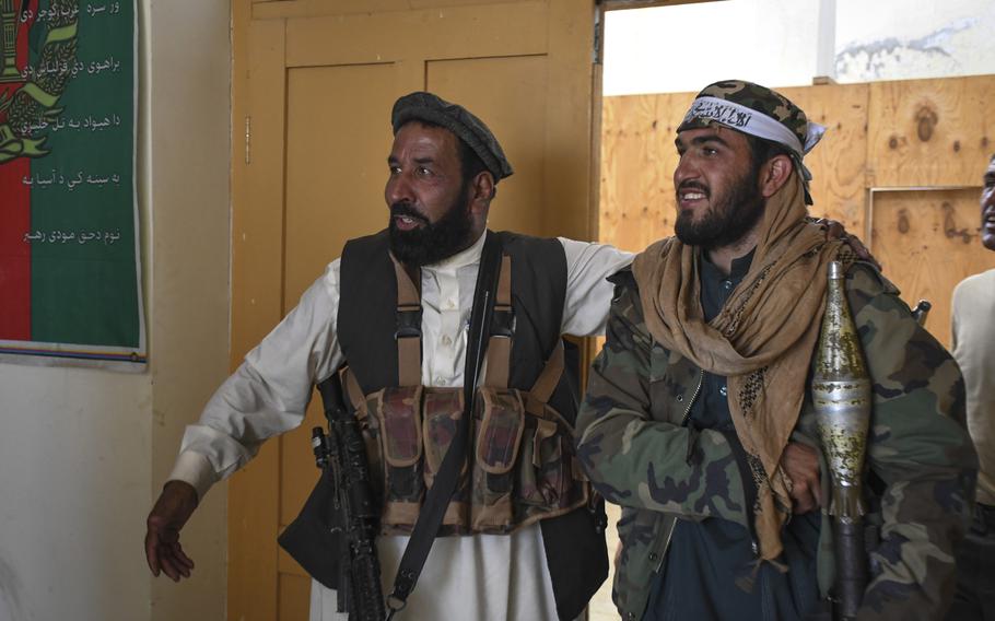 Two members of the Afghan Local Police celebrate the Eid holiday during a cease-fire between the Taliban and government forces June 16, 2018. The U.S. plans to end funding for the police group by this fall.