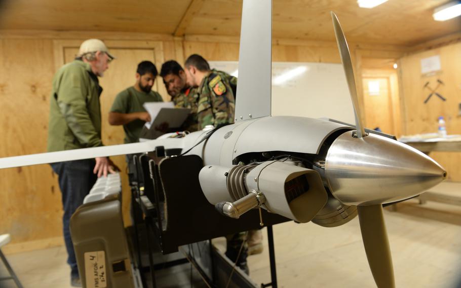 Trainee maintainers check a manual on the ScanEagle unmanned aerial vehicle outside the city of Mazar-e-Sharif on Wednesday, Oct. 26, 2016. Afghanistan's $174 million surveillance drone program has been plagued by issues, including inadequate training and missing equipment, a government watchdog agency said in a new report.