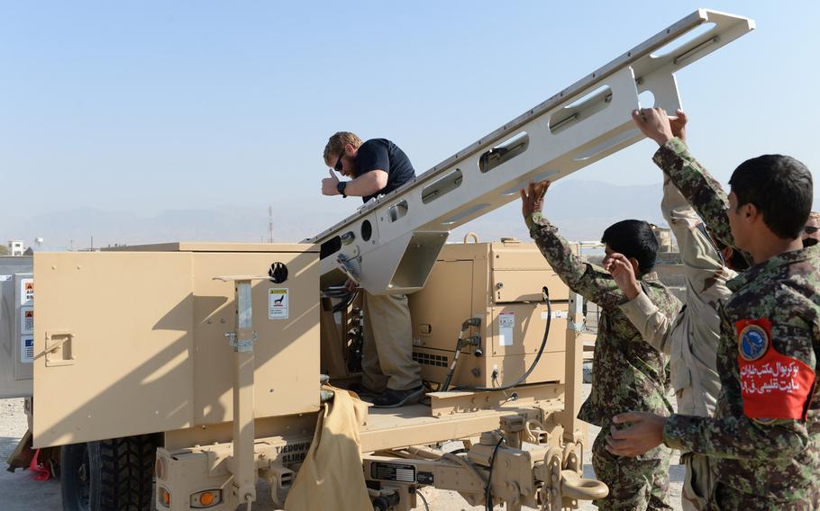 Instructor Cody Cavender helps set up the ScanEagle drone launcher outside a training center near the city of Mazar-e-Sharif on Wednesday, Oct. 26, 2016. Afghanistan's $174 million surveillance drone program has been plagued by issues, including inadequate training and missing equipment, a government watchdog agency said in a new report.