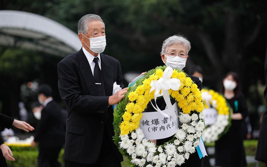 People lay a wreath at the cenotaph for the victims of the 1945 atomic bombing at Peace Memorial Park in Hiroshima, Japan, Aug. 6, 2020.