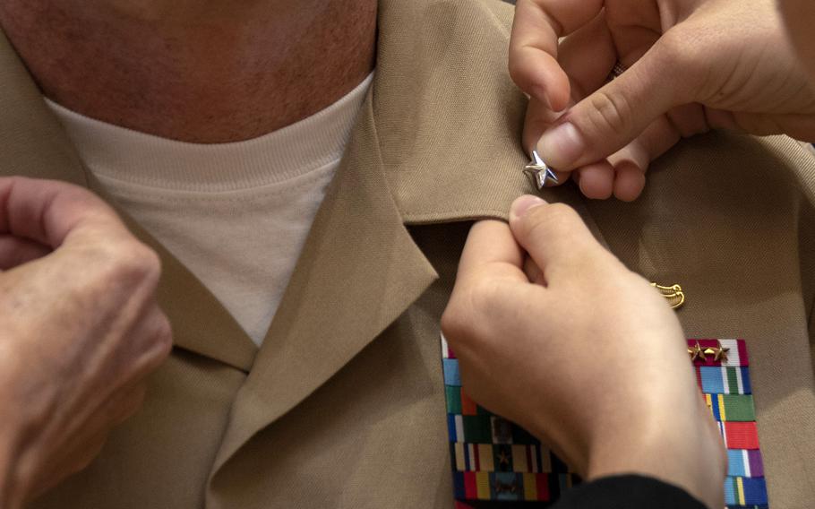 A rear admiral gets his star pinned to his uniform in 2019.  A recent Rand Corp. study said the armed services trains and promotes its flag officers in different ways.