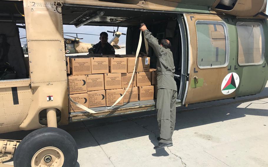 An Afghan helicopter is loaded with boxes of Meals, Ready to Eat. The U.S.-led NATO mission in Afghanistan teamed up with local forces to deliver supplies to civilians affected by recent floods.