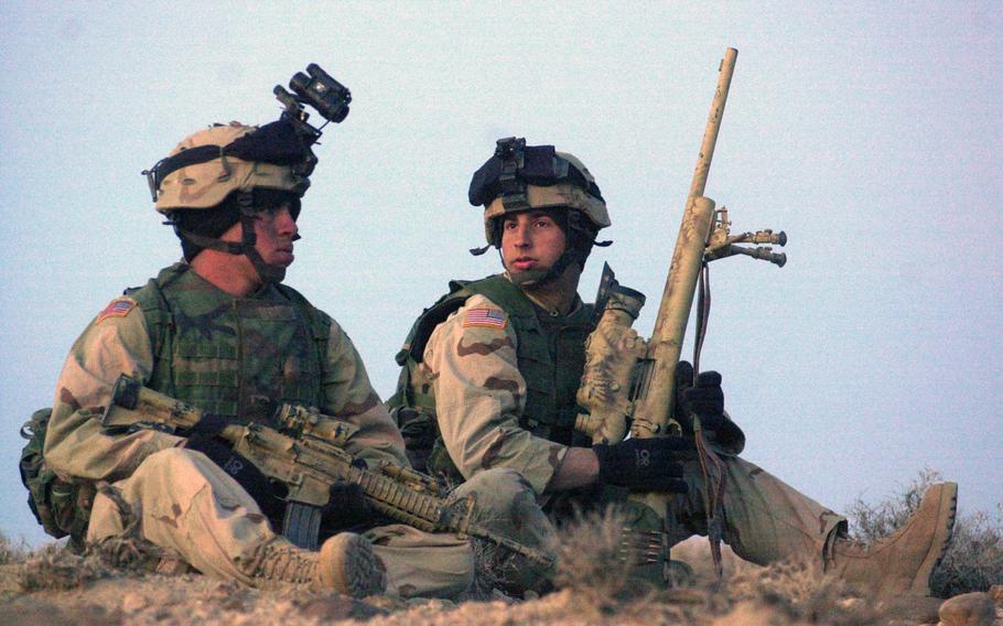 Spc. Mario Davis, left, and Spc. Barry Josey of the 10th Mountain Division, watch a mountain pass February 2004, as they try to intercept Taliban fighters. Veterans of the war are divided about the U.S. withdrawal from Afghanistan, with some bitter that the pull-out was born out of a deal with the enemy they fought, while others say it's time to end American involvement in a wasteful war.