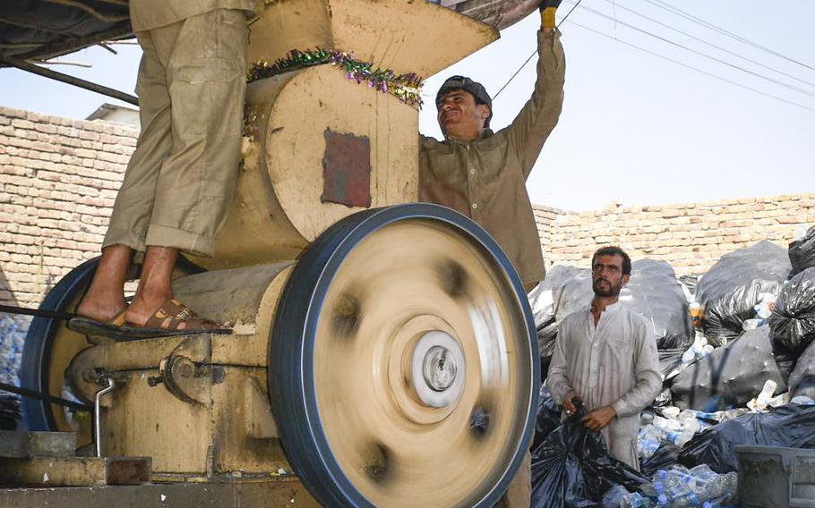 Workers shred plastic bottles from the U.S. Embassy on Aug. 17, 2020 at a recycling site near Kabul airport that the Afghan government says is illegal.
