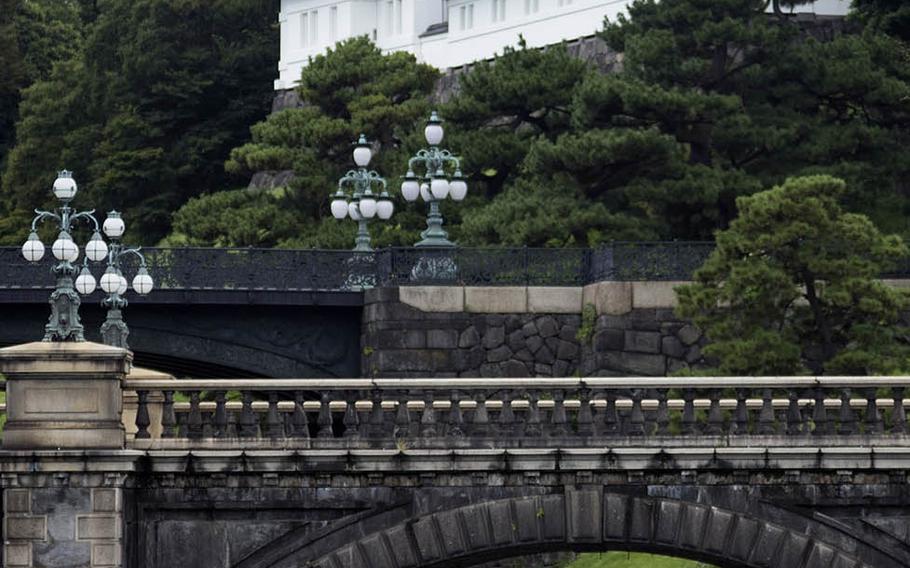 Travelers stand outside the Imperial Palace grounds in central Tokyo, Sept. 3, 2020.