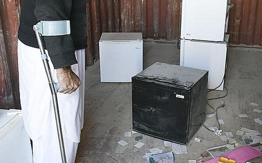 A man shops for refrigerators on Saturday, Oct. 31, 2020, in Kandahar, Afghanistan, at a bazaar where goods that once belonged to U.S. and NATO troops and contractors at Kandahar Airfield are sold to locals.