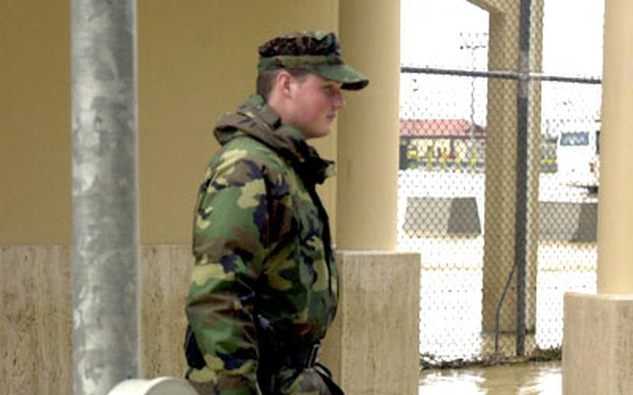 Seaman Apprentice Jack Eagling, a Naval Air Station Sigonella security patrolman, wades through flood waters that rolled onto Sigonella’s operational base Wednesday.