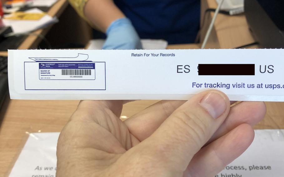 A customer holds up an express mail tracking number for a ballot for the U.S. elections sent from the Army Post Office at Kleber Kaserne in Kaiserslautern, Germany, on Oct. 1, 2020.