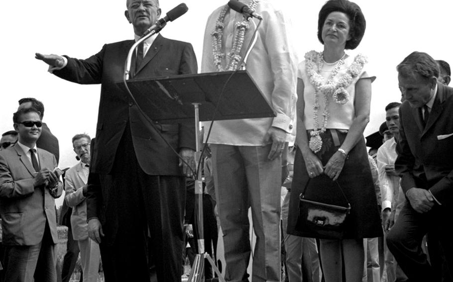 President Johnson gestures as Philippine President Ferdinand Marcos speaks and first lady Lady Bird Johnson listens.