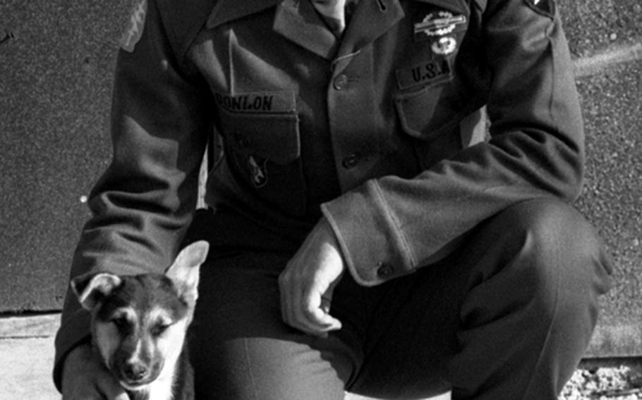 Maj. Roger Donlon, the first Medal of Honor recipient in the Vietnam war, poses outside his headquarters tent at the Advanced Combat Training Academy. With him is the camp's mascot, "Lieutenant."