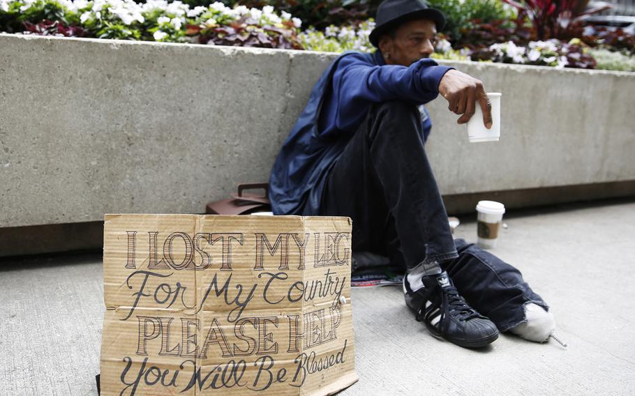 Mike Droney, a homeless veteran, displays a redesigned cardboard sign in downtown Chicago on July 2, 2015. (Michael Noble Jr./Chicago Tribune/TNS)