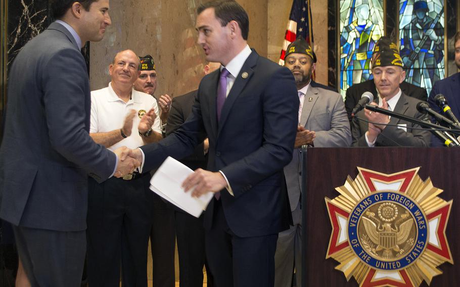 Rep. Mike Gallagher, R-Wis., shakes hands with Rep. Seth Moulton, D-Mass., at the Global War on Terror Memorial press conference, March 28, 2017.