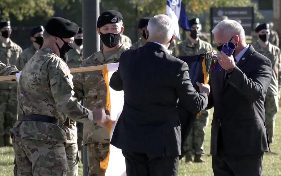  Lt. Gen. John Kolasheski, V Corps commanding general, Command Sgt. Maj. Billy Webb, former V Corps commander retired Lt. Gen. James Terry and retired Command Sgt. Maj. William Johnson, from left, unfurl the V Corps colors at the unit's activation ceremony Oct. 16, 2020, at Fort Knox, Ky.
                