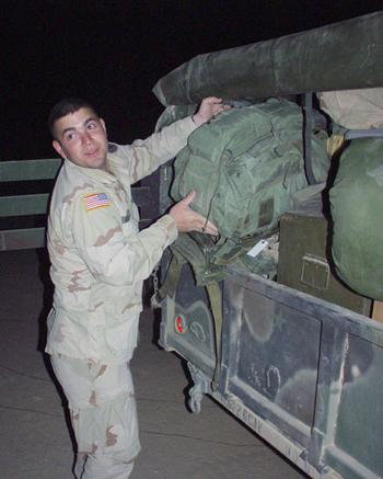 Spc. Santos Bazan, 22, a driver for the 2nd Squadron, 6th Cavalry Regiment’s commanding officer, stows gear aboard a Humvee trailer just before the unit leaves in a long convoy from Camp Udairi, Kuwait, to a new base in central Iraq.