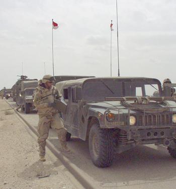 Maj. Carl Coffman, executive officer of the 2nd Squadron, 6th Cavalry Regiment from Illesheim, Germany, stands outside the lead vehicle of his unit’s convoy during the 69-hour journey from Camp Udairi, Kuwait, to their new post in central Iraq.