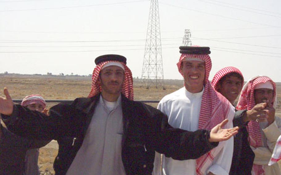 Boys and young men in a villager near As-Samawah, Iraq, greeted 11th Aviation Regiment soldiers with smiles as they passed through their town. Some of them waves American flags.