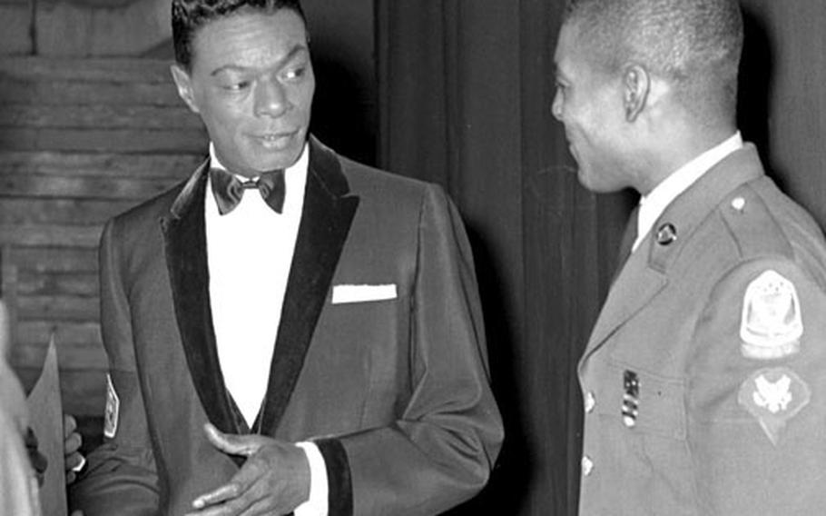 Nat King Cole talks with Sp4 Ernest Williams of HQ Det., Korean Military Advisory Group, prior to Cole's performance at the Municipal Auditorium in Seoul on March 1, 1963.