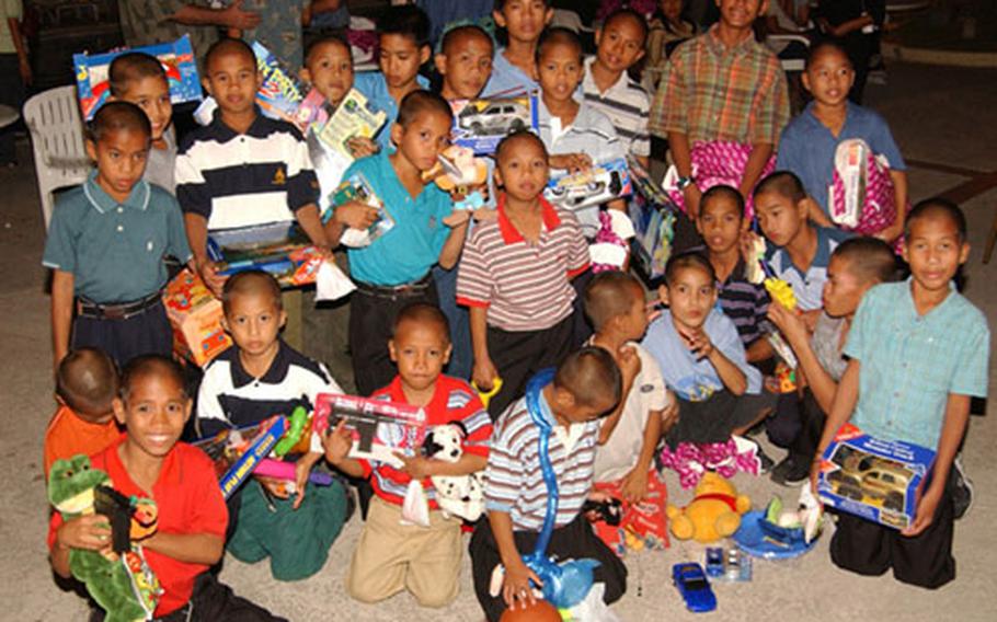 Boys from the Angeles Bahay Bata Center, Angeles City, Philippines, pose with the toys they received from the Marines and Sailors of the 3rd Marine Expeditionary Brigade after a recent Christmas party.