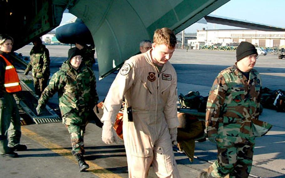 Members of the 435th Contingency Aeromedical Support Facility (CASF) at Ramstein Air Base, Germany, carry an injured servicemember off a medevac plane. Injured troops are taken to the facility before being transported to Landstuhl Regional Medical Center for further treatment.