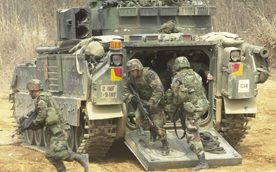 Members of the 1st Battalion, 9th Infantry Regiment based at Camp Hovey, South Korea, run out of a Bradley fighting vehicle as they practice taking a bunker at Rodriguez Range last week.