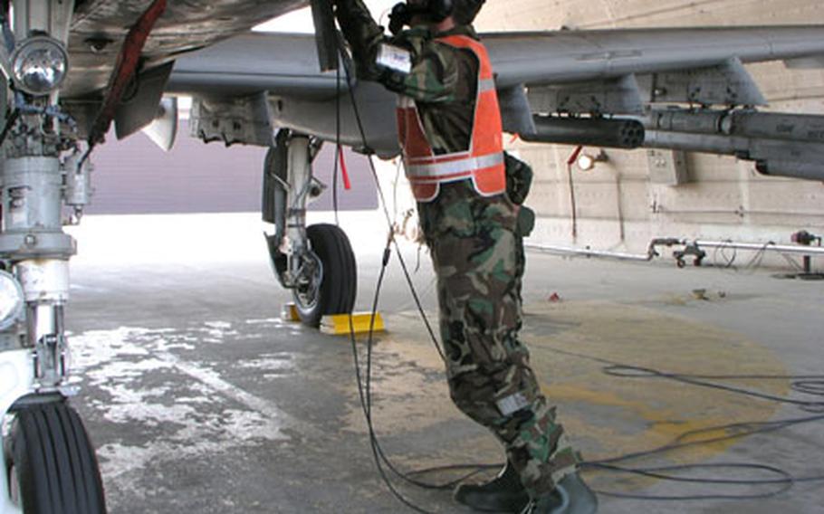 During combat readiness exercise this week at Osan Air Base, South Korea, Senior Airman Dusty Surber reaches toward a panel on this U.S. Air Force A-10 attack plane.