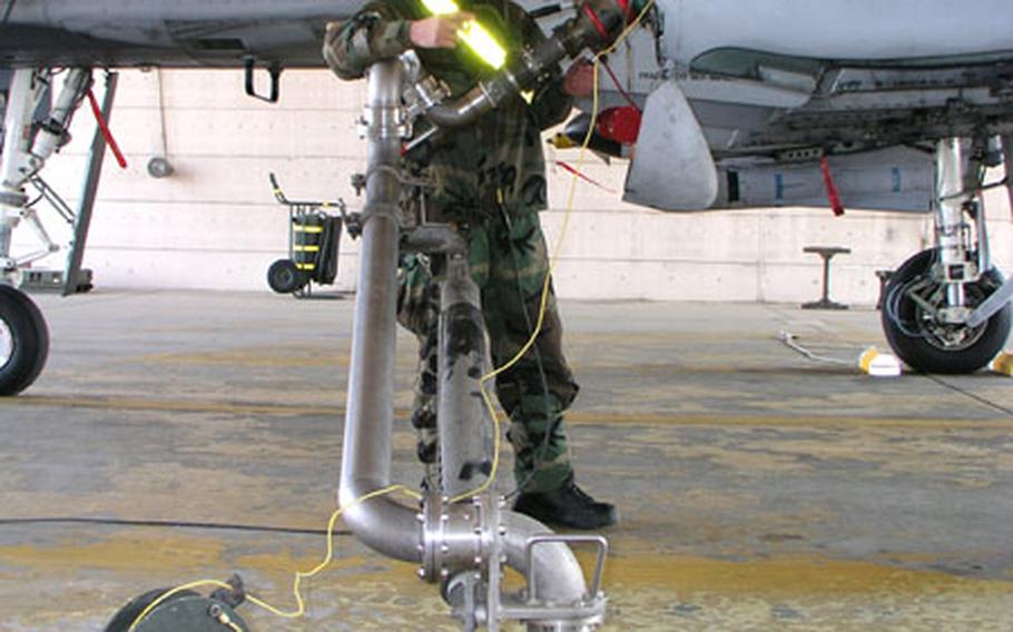 At Osan Air Base, South Korea, Senior Airman Stephen Perry fuels an A-10 attack plane of the 51st Fighter Wing, while the aircraft's engines are running, a fueling method known as hot pitting.