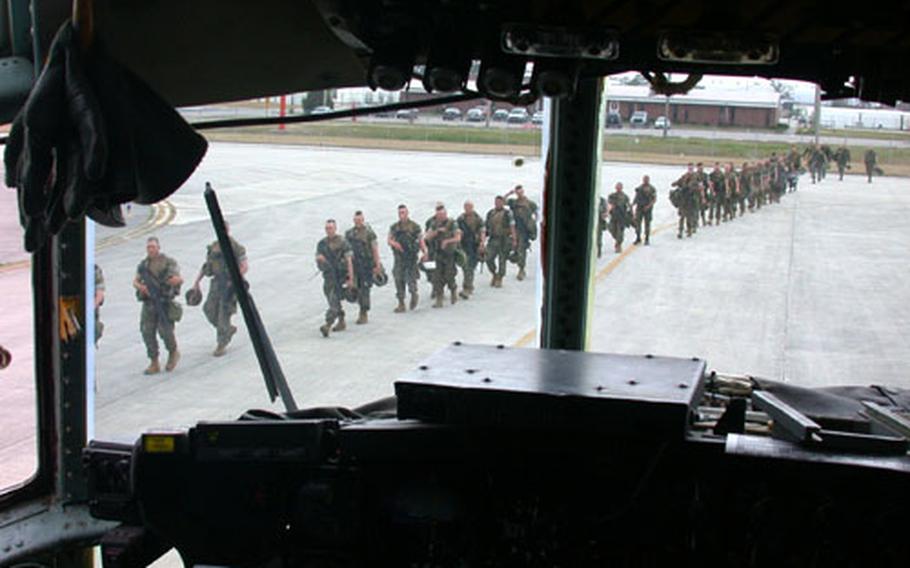 U.S. Marines from 3rd Battalion, 8th Marines stationed at Camp Lejeune, N.C., march to board a C-130 waiting at nearby Cherry Point, N.C., to fly them to Haiti for a deployment that the Marines have been told could last from two to six months.