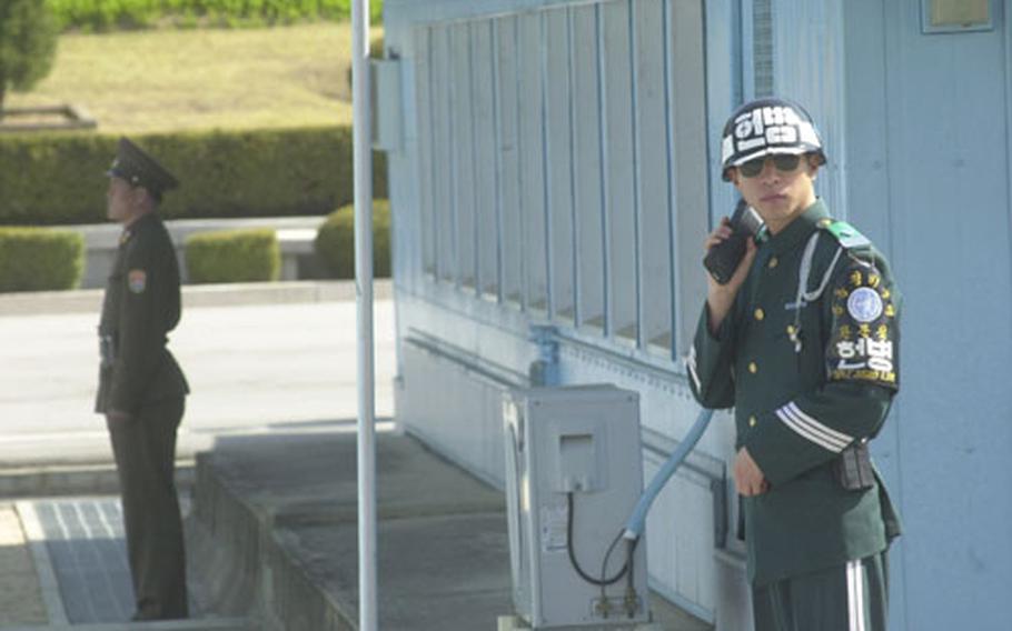 A South Korean soldier stands guard in the Joint Security Area Wednesday at Panmunjom during a media tour while a North Korean guard is visible in the background.