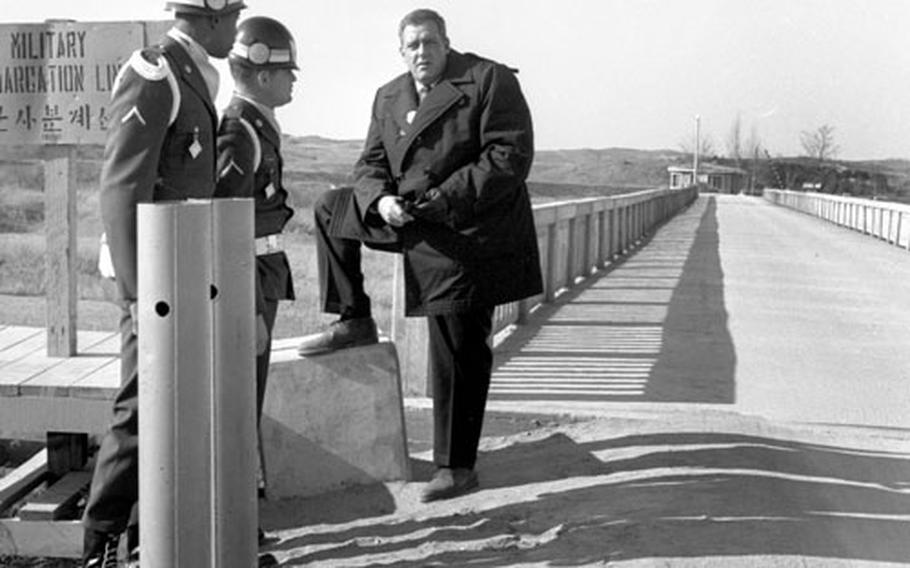 Korean Demilitarized Zone, December 26, 1963: Joint Security Agency MPs Pfc. Earnest Clark, left, and Pfc Michael J. Mahoney, center, explain their position at the "Bridge of No Return" between North and South Korea to actor Raymond Burr, right. The "Perry Mason" (and, in later years, "Ironside") star shook thousands of hands and braved below-freezing temperatures for several days while visiting troops in Korea; he then moved on to Japan and Okinawa.