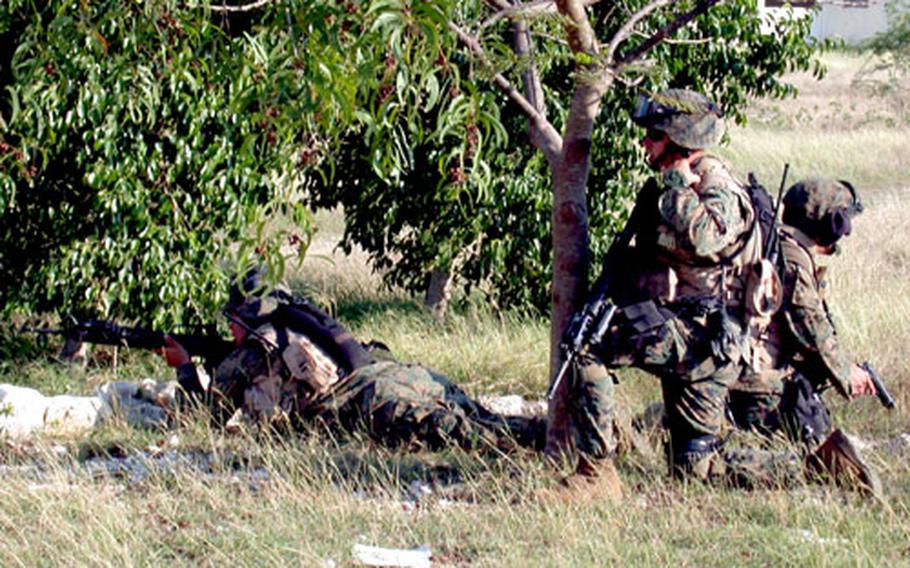 U.S. Marines from 7th Platoon, 2nd FAST Company make up the containment team securing the perimeter of a compound used during a training exercise Saturday. The exercise, during which the Marines practiced a raid on two targets believed to house drug and weapons smugglers, provides “real world” training to keep skills sharp while deployed to Haiti.