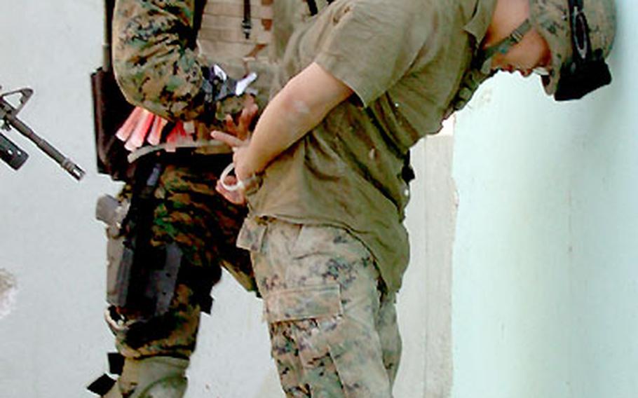 Lance Cpl. Leighton Becker, 21, with 7th Platoon, 2nd FAST Company, searches one of three “suspects,” portrayed by Lance Cpl. Michael Tani, 20.