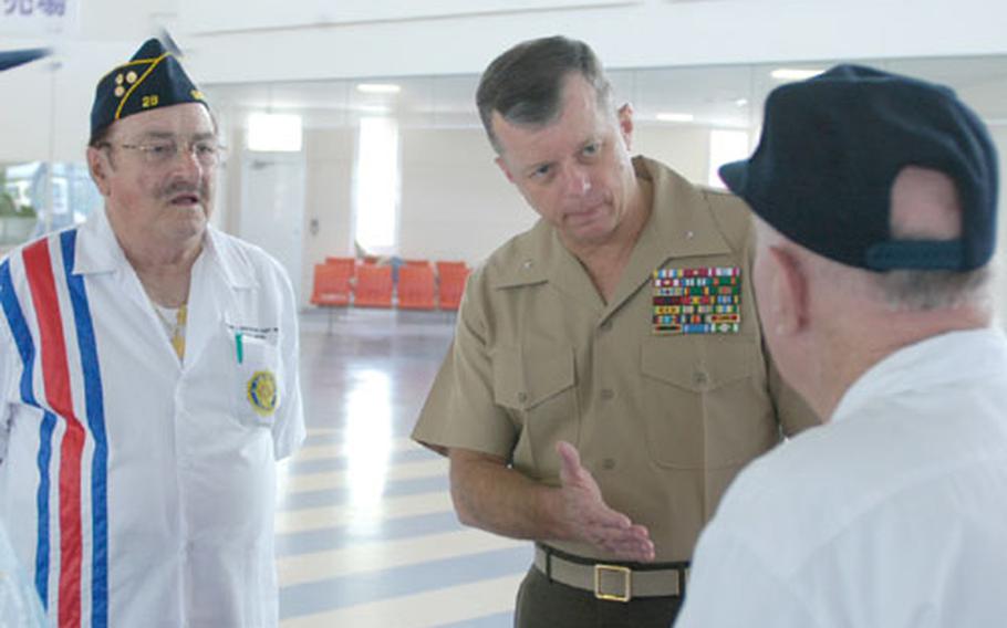 Marine Brig. Gen. Frank A. Panter, commanding officer of 3rd Force Service Support Group, talks with Ray Rossini, left, and Edward Zobreck, right, members of American Legion Post 28, on the ferry to Ie Shima.