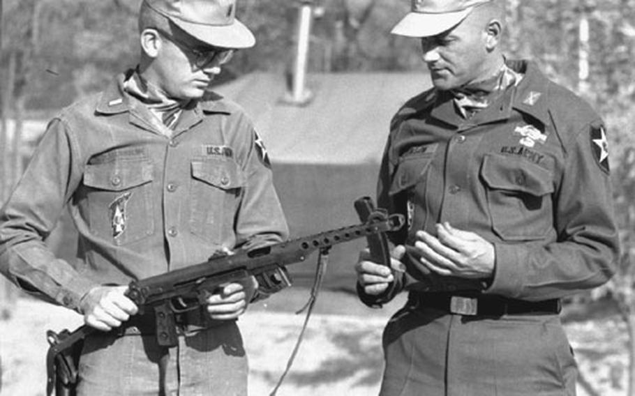 1st Lt. Paul Wolstenholme, left, and Maj. Roger Donlon examine a Russian PPS-4 automatic weapon at the Advanced Combat Training Academy at Camp Sitman, South Korea, in 1967.