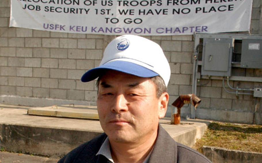 USFK Korean Employees Union Kangwon chapter representative Yi Un Song stands in front of a banner protesting plans to close Camp Page.