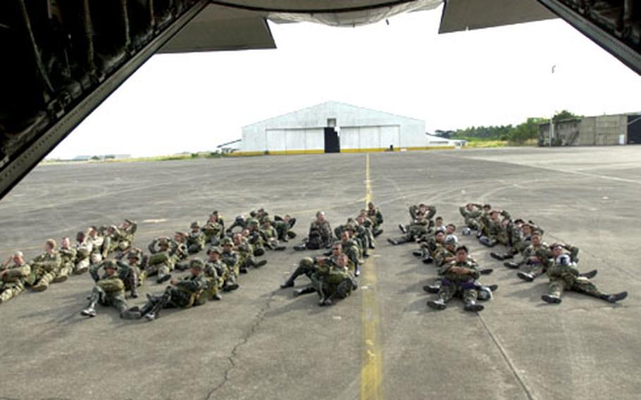 U.S. and Filipino Marines sit on the ground outside the plane they will be jumping out of during Exercise Talon Vision 05. The troops were loaded on the plane, but were filed off after mechanical problems first delayed, then canceled their flight.