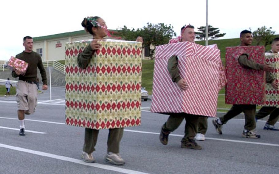 Marines, kids and others dressed as gifts make their way down the parade route during Camp Kinser’s annual Christmas parade Wednesday on Okinawa.