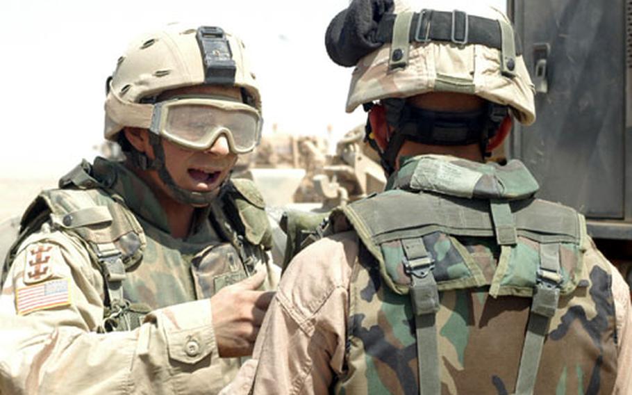 Spc. Ryan Ristow, left, explains to Spc. Brandon Brooks how sand came into the Humvee he was driving and covered his face, hands and goggles with white dust during a convoy to Command Outpost Rawah, Iraq, last week.