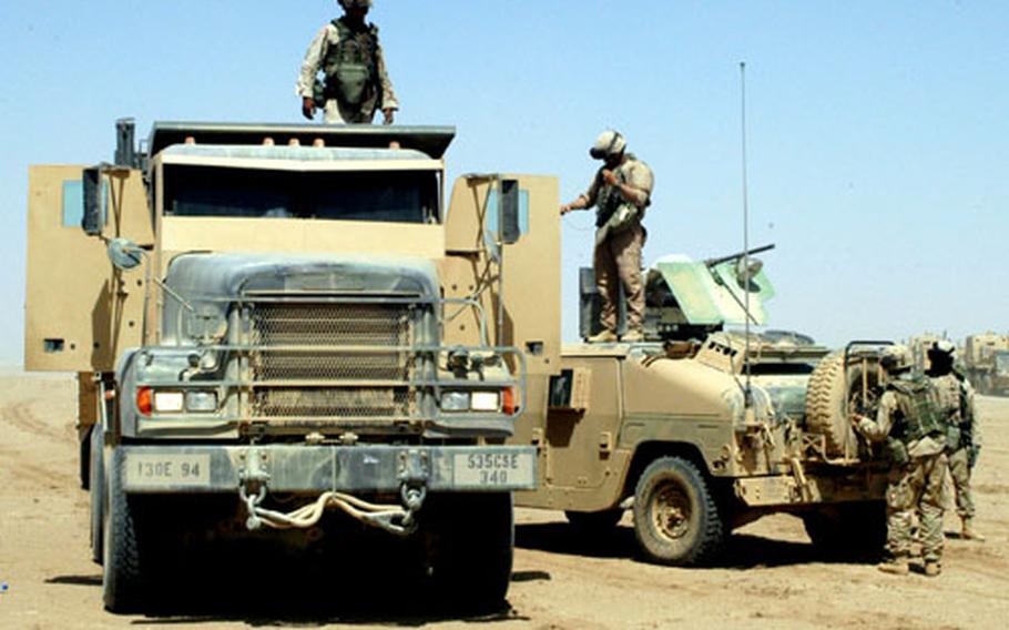 Soldiers from the 535th Engineer Company (Combat Support Equipment) and Company A, 94th Engineer Combat Battalion (Heavy) check their vehicles and stretch their legs Friday during a scheduled rest stop about two-thirds of the way to Command Outpost Rawah.